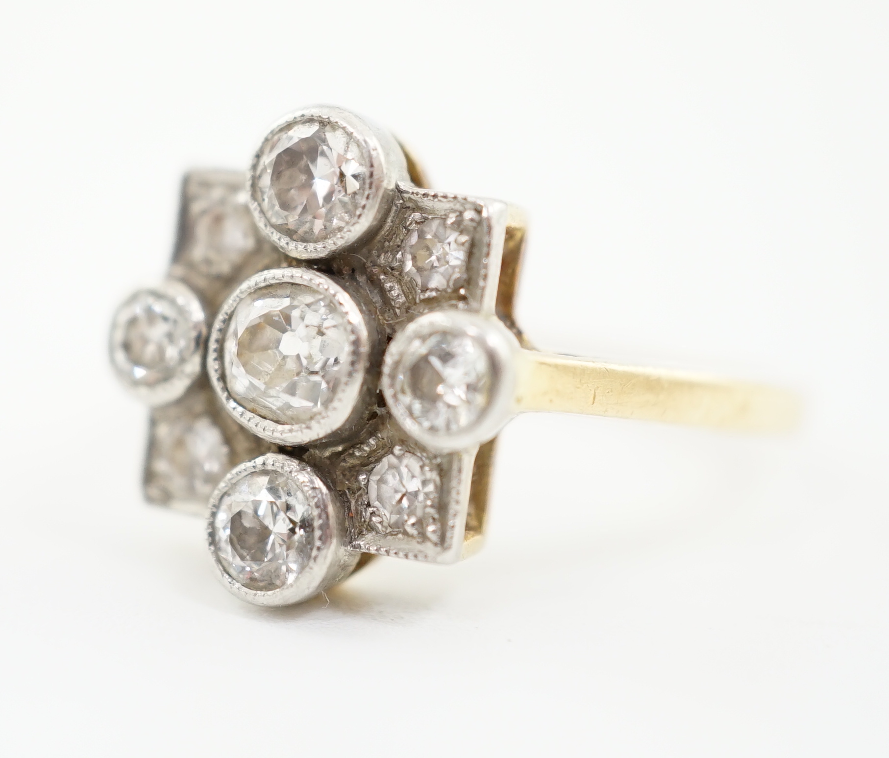 A 1920's/1930's 18ct gold, platinum and millegrain set nine stone diamond cluster ring